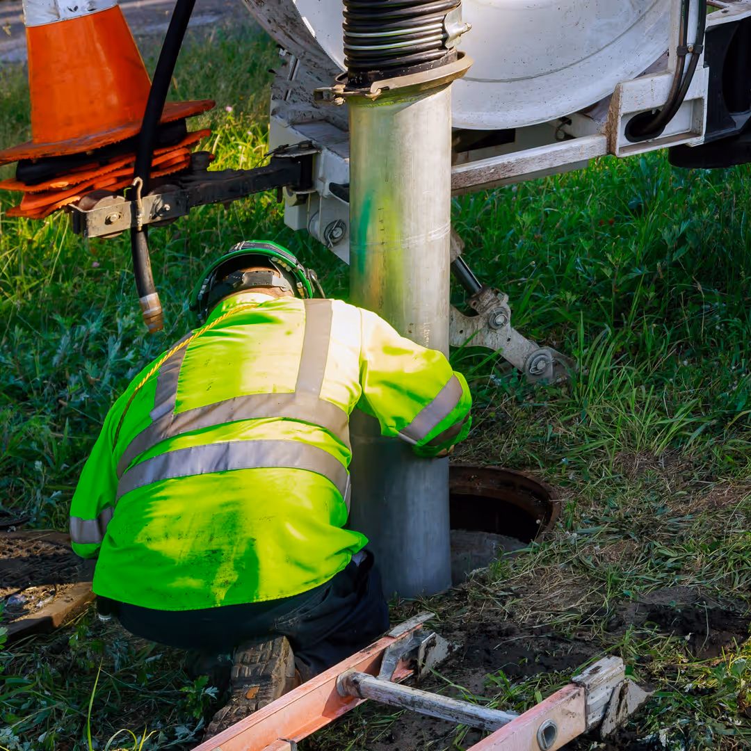 A technician inspecting an opened septic tank